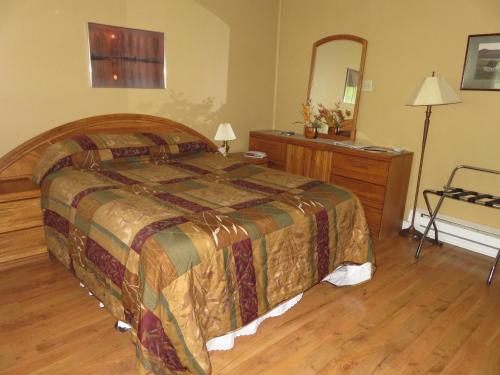 CormackLush's Cottages的一间卧室配有一张大床和镜子