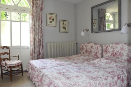 武夫赖Le clos des Acanthes的一间卧室配有一张床、一把椅子和镜子