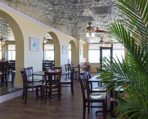 默特尔比奇沙丘套房度假酒店的用餐室设有桌椅和窗户。