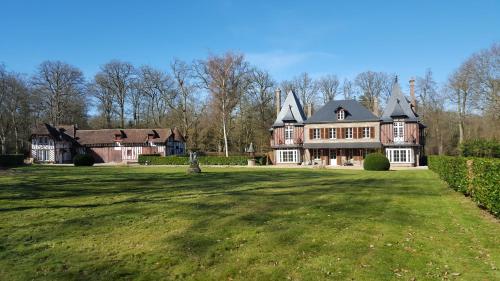 Arnières-sur-ItonManoir du Chambellan的大房子,有大草地庭院