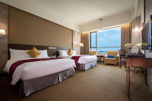 嘉义市嘉义皇品国际酒店的酒店客房配有两张床和一张书桌