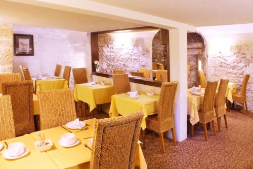 讷韦尔Best Western de Diane - restaurant TAM's Cuisine Maison的用餐室配有黄色的桌椅