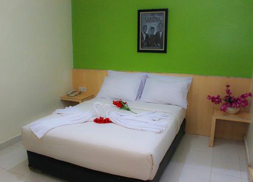 北干巴鲁Sabrina Paninsula的卧室配有带鲜花的白色床