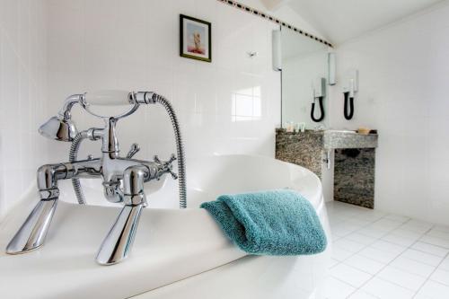 蒙彼利埃贝斯特韦斯特奎尔姆酒店的白色的浴室设有水槽和浴缸。