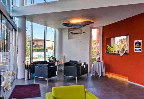 菲乌米奇诺罗马机场贝斯特韦斯特酒店的大楼内一个带沙发和椅子的大堂