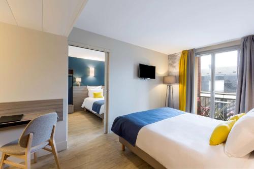 卢瓦尔河畔默恩拉波特德斯查特奥克斯贝斯特韦斯特酒店的配有一张床、一张书桌和一扇窗户的酒店客房