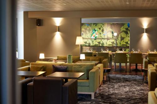 瓦朗斯克莱斯·西拉贝斯特韦斯特优质酒店的一间带沙发和桌子的餐厅和一间酒吧