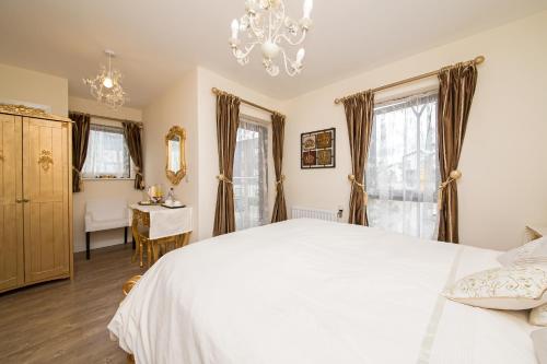 克罗伊登罗文公园旅馆的卧室配有白色的床和吊灯。