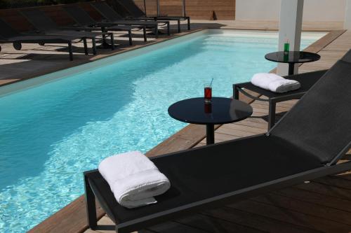 奥瑟戈尔202酒店的游泳池前设有桌椅