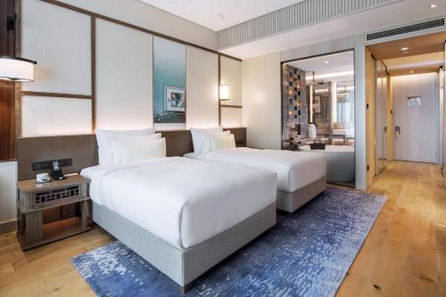 上海上海阿纳迪酒店（开启身心灵的唤活疗愈之旅）的一间带两张床的卧室和一间客厅