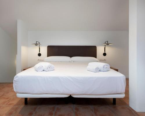 巴古尔Alta House Apartments 4 Vents的卧室配有白色的床和2条毛巾