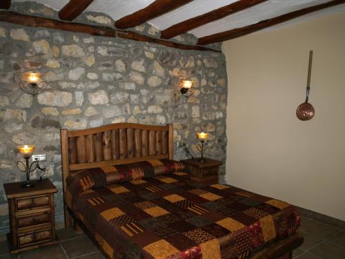 塞利亚Apartamentos turísticos La Fuensanta的一间卧室设有一张床和石墙