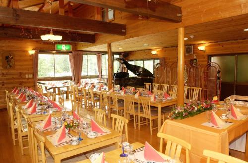 妙高索拉图布乌萨基酒店的一间带桌椅和钢琴的用餐室