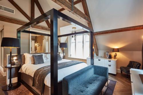 奇德尔奥迪费洛切公园酒店的一间卧室配有一张大天蓬床和一张蓝色椅子