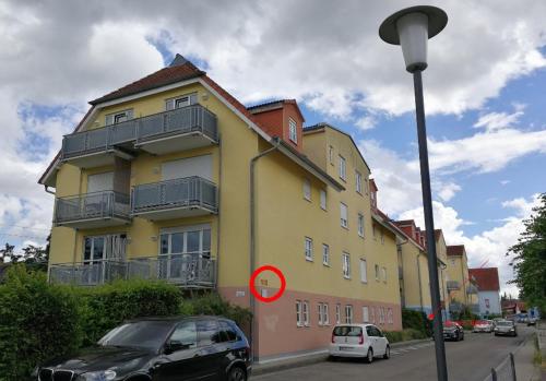 海德堡海德堡夏洛特公寓的一座黄色的建筑,前面有汽车停放