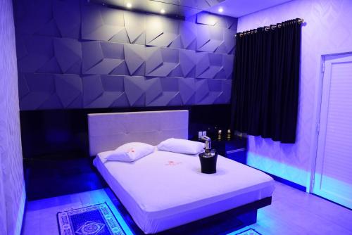 帕苏丰杜Helus Motel的紫色的客房配有一张带白色床单的床