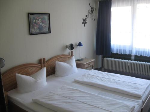 特里贝格伽尼中心酒店的一间卧室配有一张带白色床单的床和一扇窗户。