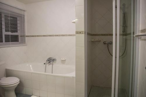 斯瓦科普蒙德Sand & Sea Holiday Home的带浴缸、卫生间和淋浴的浴室。