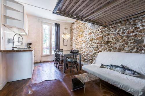 巴黎Cosy 40m² near MONTMARTRE的厨房以及带沙发和桌子的客厅。