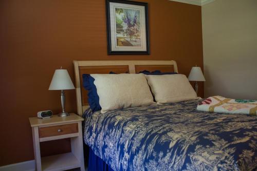 Genelle格尼勒住宿加早餐旅馆的一间卧室配有一张床和一个带两盏灯的床头柜。