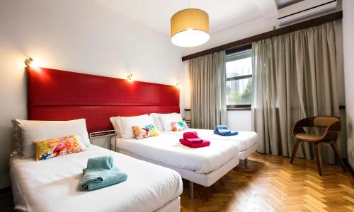 波尔图科莱里格RE2街LV高级公寓的酒店客房设有两张床和红色床头板