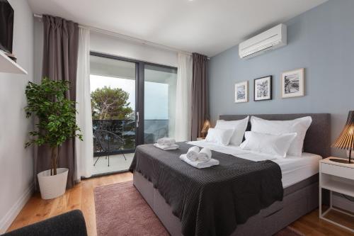 马卡尔斯卡Villa MirA with fantastic sea view的一间卧室设有一张大床和一个大窗户