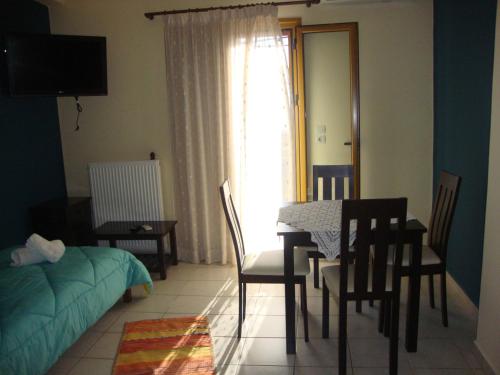 皮尔戈斯迪鲁Kafiona Guesthouse的一间带桌椅的客厅和一间卧室