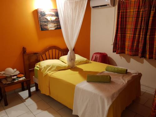 圣安娜Bel Appartement - proche des plages de Sainte Anne的一间卧室设有黄色的床和窗户。