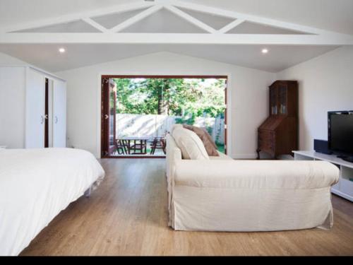 FreshwaterBijoux Beach House的一间带两张床和一张沙发的客厅