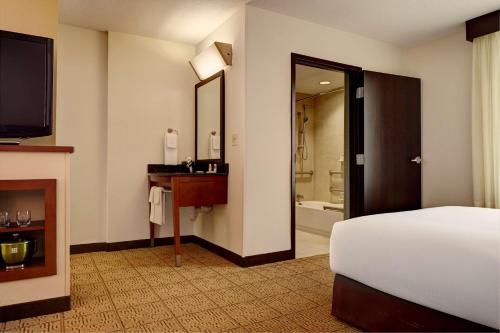 盐湖城盐湖城市中心关口凯悦广场酒店的酒店客房设有床、电视和浴室。