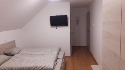 OsluševciGostilna Marta的一间卧室配有两张床和一台平面电视