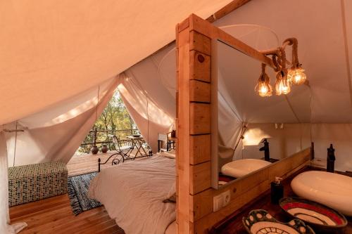 韦伯斯卡Plage Cachée - Glamping的帐篷内的卧室配有床和水槽