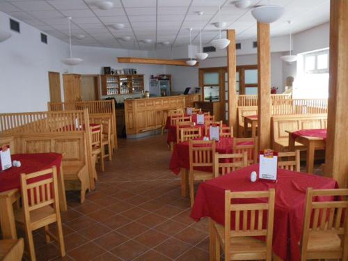 什平德莱鲁夫姆林Horská chata Sedmidolí的餐厅设有木桌、椅子和红色桌布