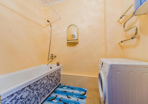 赤塔Dekabrist Apartment Oktyabrski的带浴缸和洗衣机的浴室。