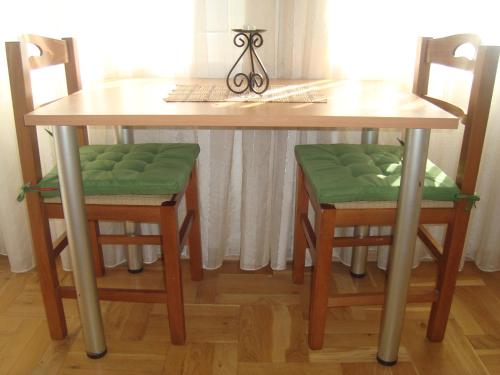 奥赫里德Villa Afrodita的一张带两把椅子的木桌、一张桌子和一张桌子以及椅子