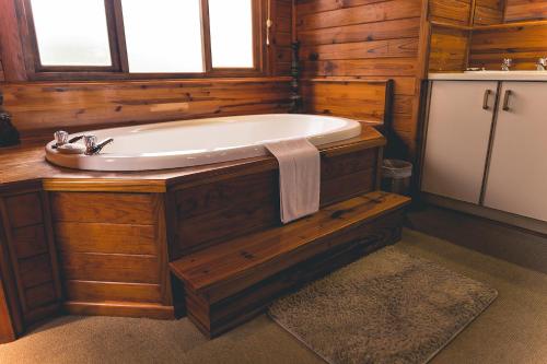 克尼斯纳Oyster Creek Lodge的木制浴室设有浴缸和水槽