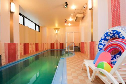 小樽月神海岸情趣酒店（仅限成人）的一个带两把椅子的游泳池和一个游泳池
