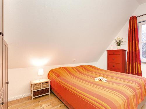 格洛韦Ferienhaus Auszeit - D 120.017的一间卧室配有一张床、一个梳妆台和一扇窗户。