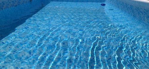 CollesanoAgriturismo Ilardo的靠近一个蓝色的游泳池
