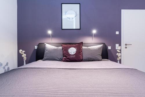 黑尔博尔茨海姆Parkside Boutique Appartements的一间卧室设有一张紫色墙壁的大床