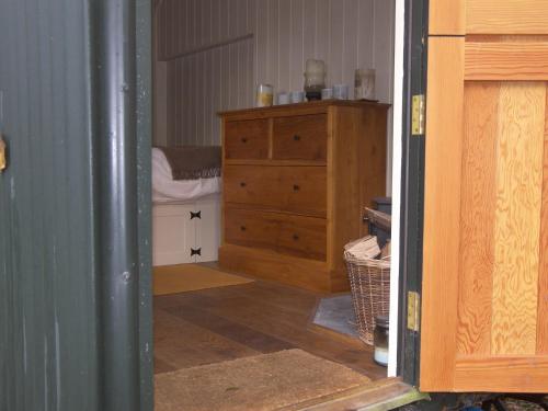 文特诺The Hut的一间带木制梳妆台和一间卧室的房间