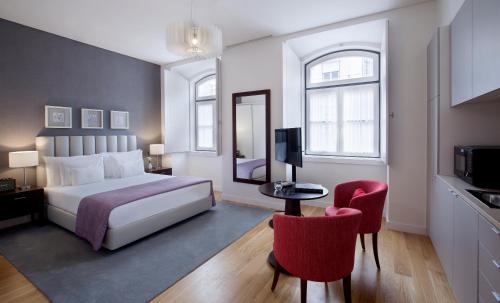 里斯本Grape Harbor Prata Apartments的酒店客房,配有一张床和两张红色椅子