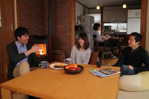 安昙野市Azumino Ikeda Guesthouse的一群人坐在桌子旁