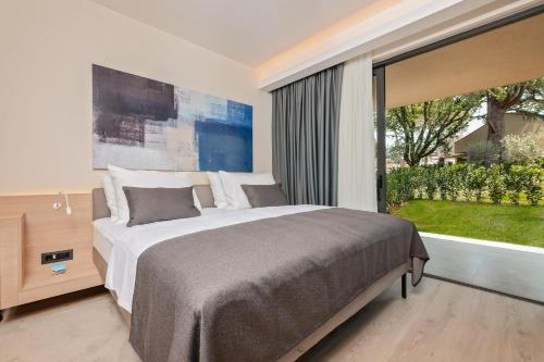 波雷奇Garden Suites Park Plava Laguna的一间卧室设有一张大床和一个大窗户