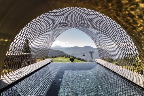 索普拉布扎诺Gloriette Guesthouse Hotel & Restaurant的透过拱门可欣赏到游泳池的景色