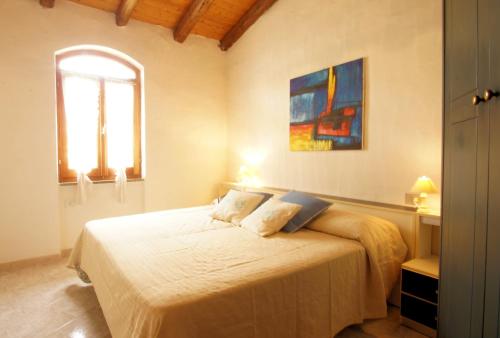 瓦雷多利亚Sa Fiorida case vacanze的一间卧室设有一张床和一个窗口