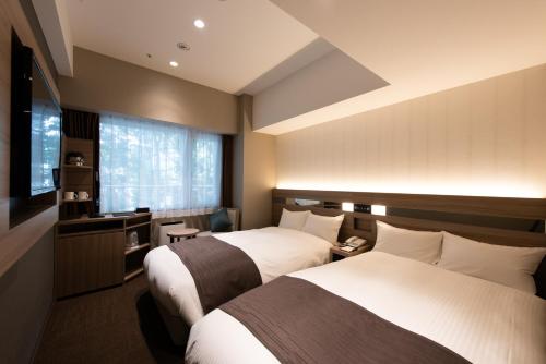 西宫市休伊特甲子园酒店的酒店客房设有两张床和窗户。