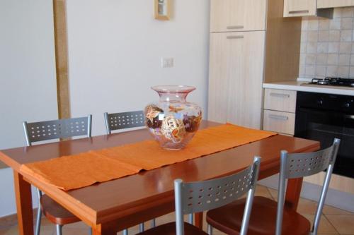 圣凯撒利亚温泉Il Corbezzolo的厨房里木桌边的花瓶