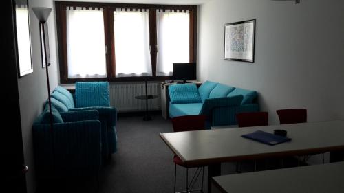 摩德纳迪-坎皮格里奥里奥法尔泽多功能酒店的一间设有蓝色椅子和桌子的等候室