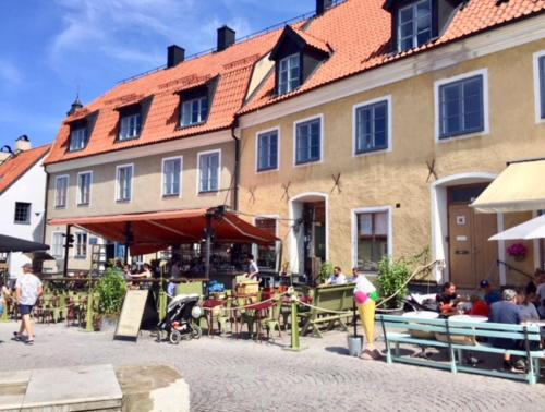 维斯比Stora Torget - Visby Lägenhetshotell的一群坐在大楼前桌旁的人